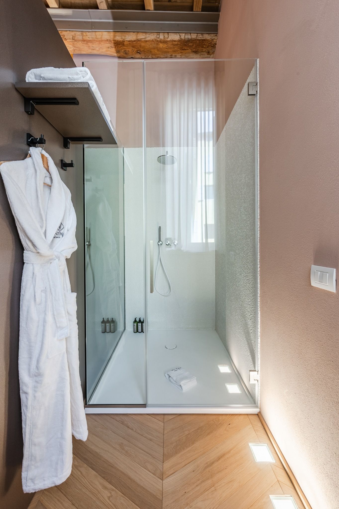 Doccia walk-in con accappatoio appeso accanto