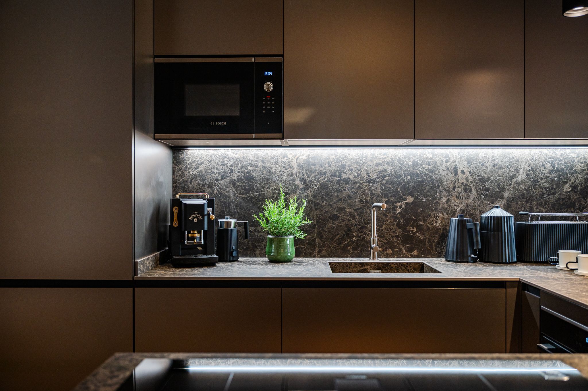 Dettaglio cucina in mood serale con backsplash in marmo illuminato