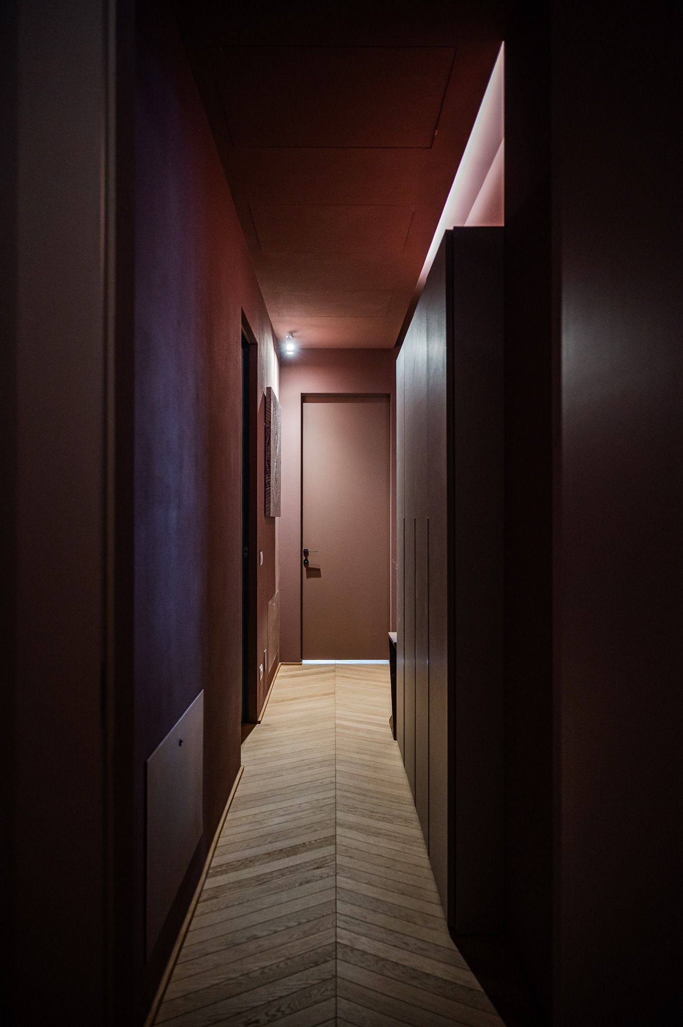 Corridoio in penombra con parquet a spina di pesce