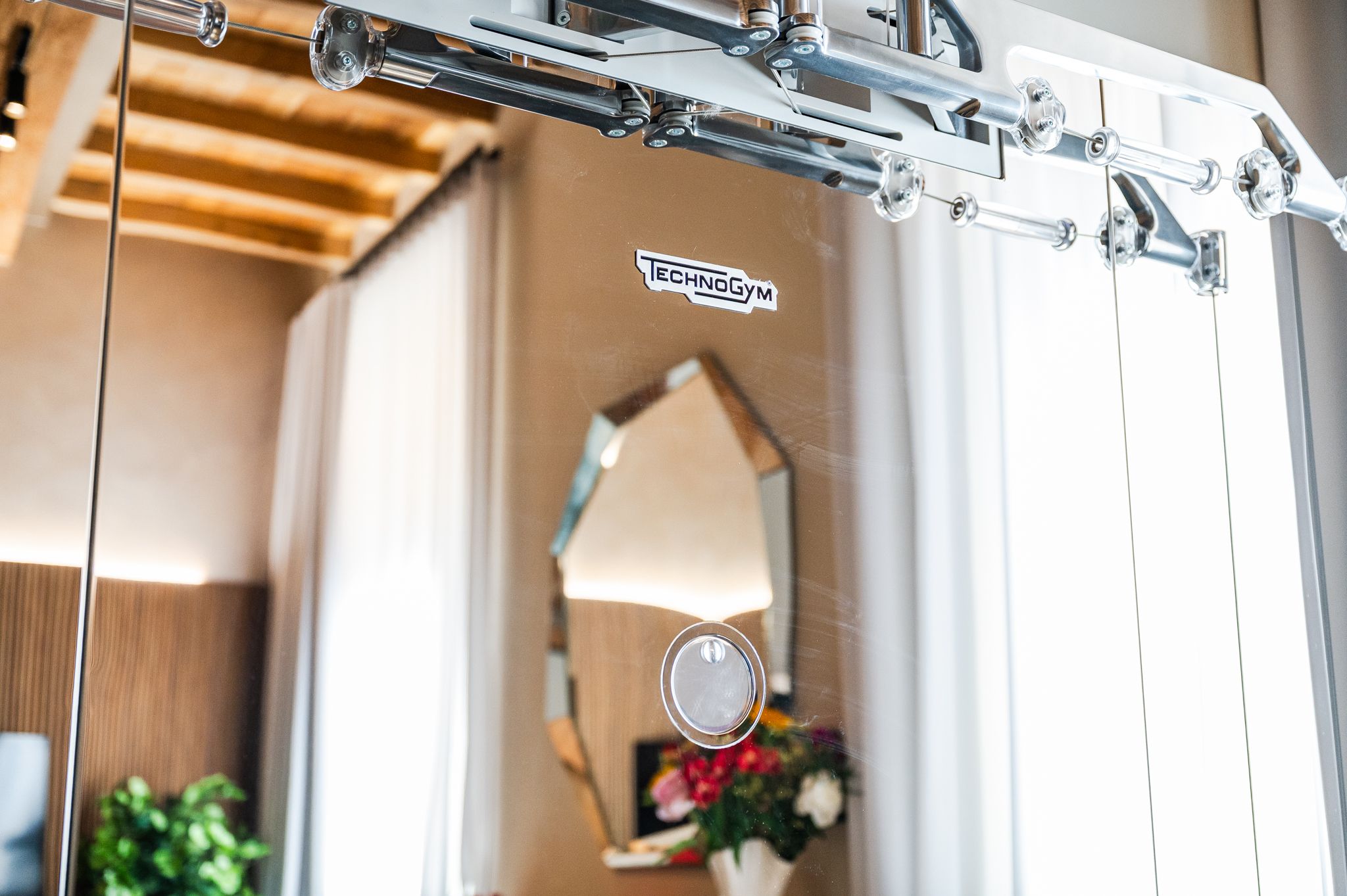 Dettaglio della stazione Technogym Kinesis con logo e riflessi dell'ambiente