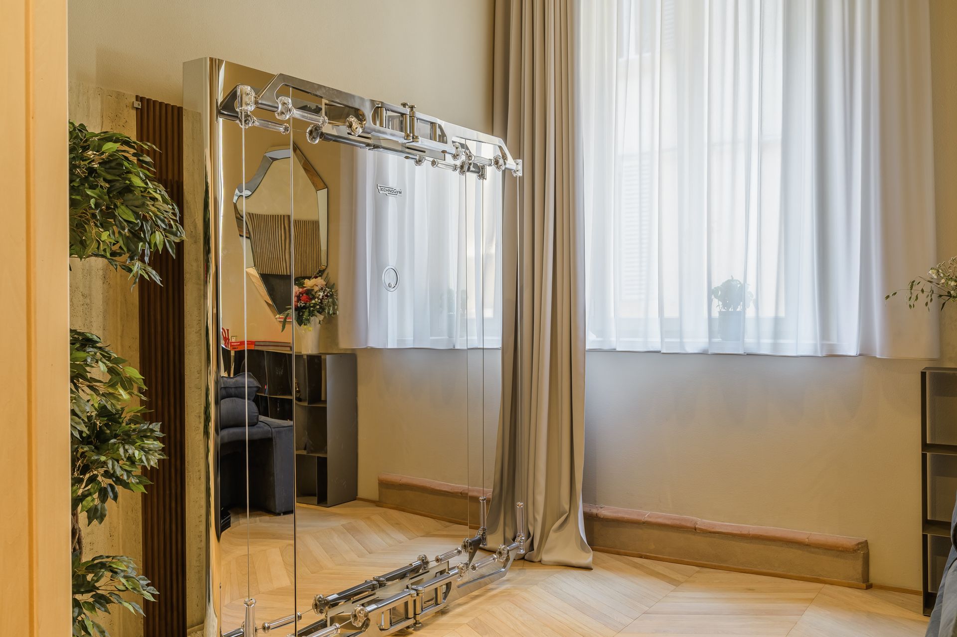 Postazione Technogym Kinesis Personal accanto alla finestra con tende